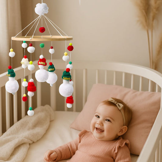 mobile bebe bonhomme de neige fille souriante dans berceau