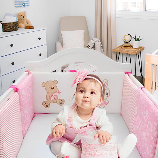 tour de lit bebe fille assise dans berceau